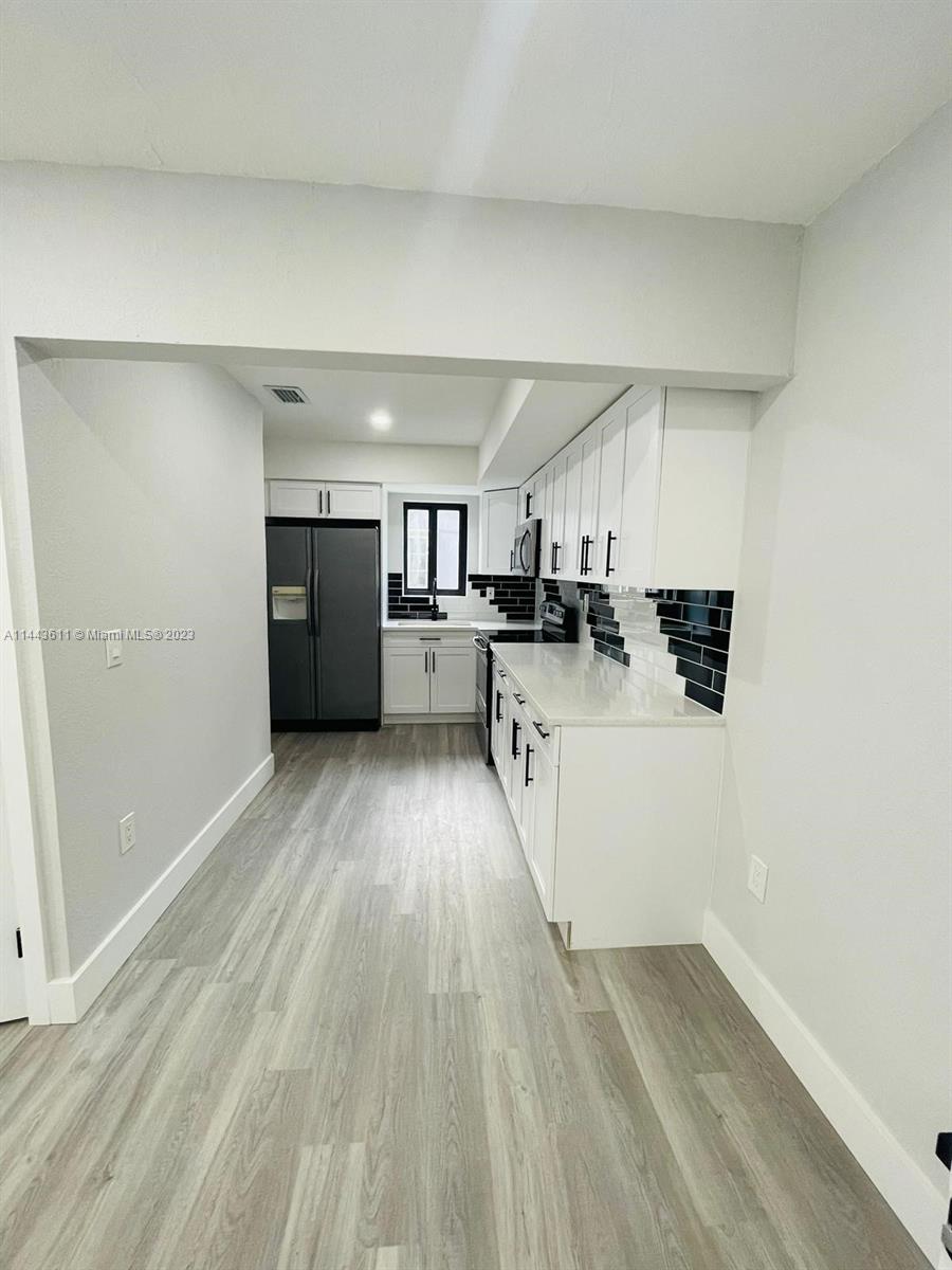 2521 Northwest 121st Street Miami, FL 33167 - Photo 5 of 43 a view of kitchen with wooden floor and electronic appliances