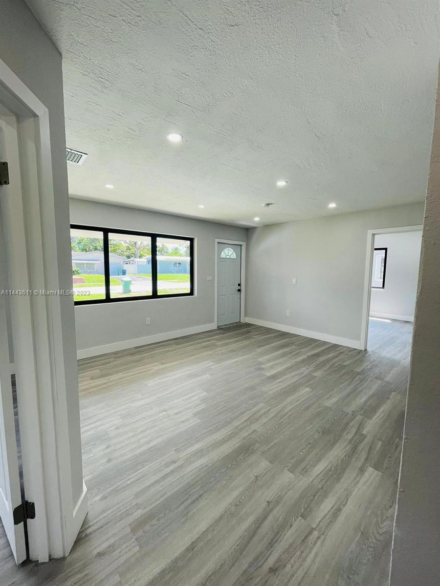 2521 Northwest 121st Street Miami, FL 33167 - Photo 7 of 43 an empty room with wooden floor and windows