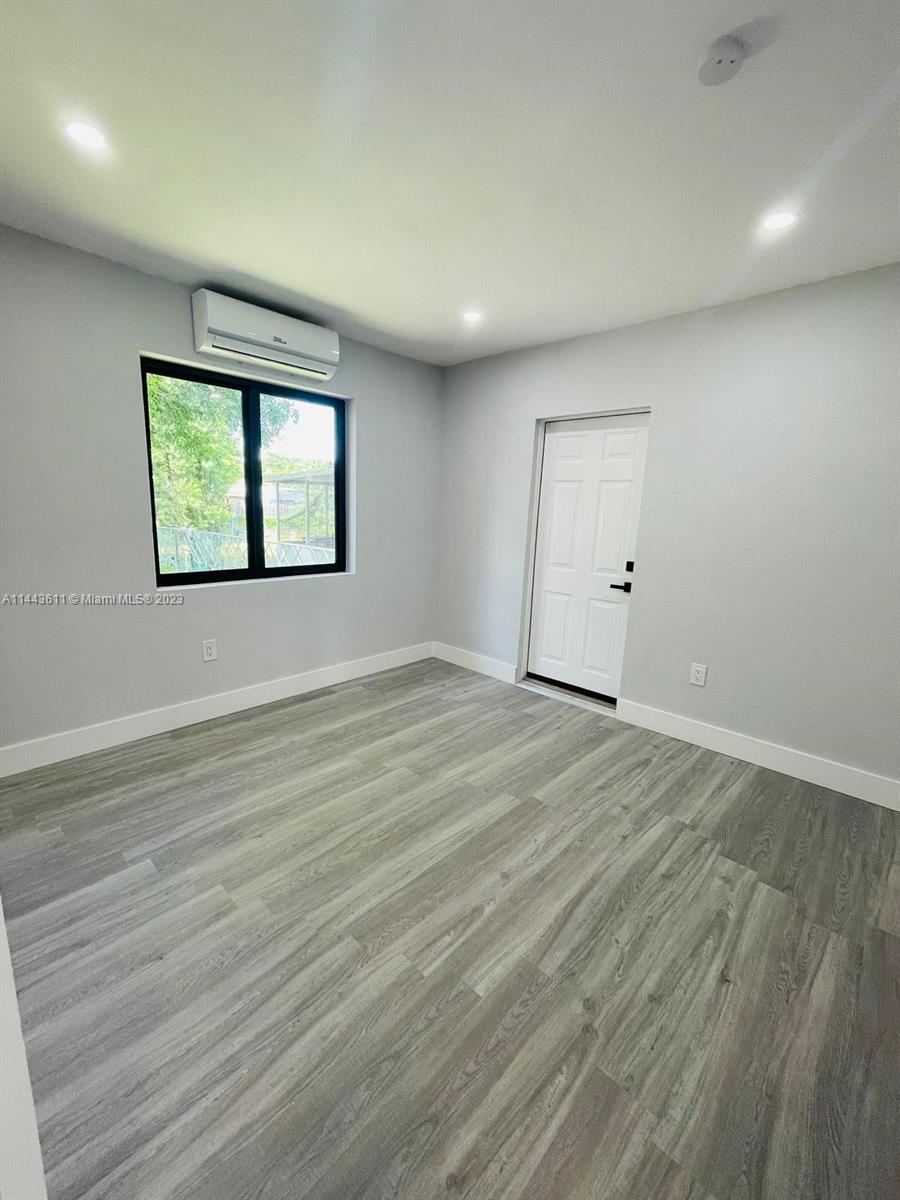 2521 Northwest 121st Street Miami, FL 33167 - Photo 10 of 43 an empty room with wooden floor and windows