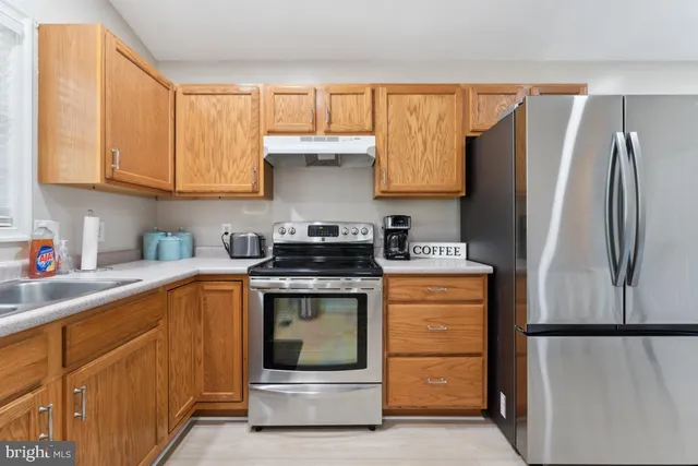 a kitchen with stainless steel appliances granite countertop a refrigerator and a stove