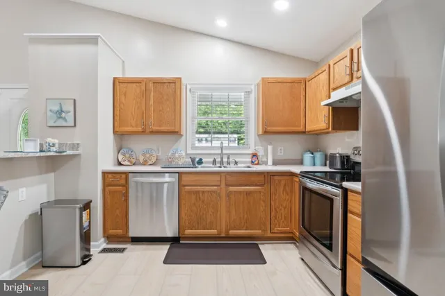 a kitchen with stainless steel appliances granite countertop a stove a sink and a refrigerator