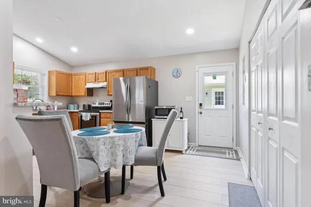 a dining room filled chandelier and kitchen view