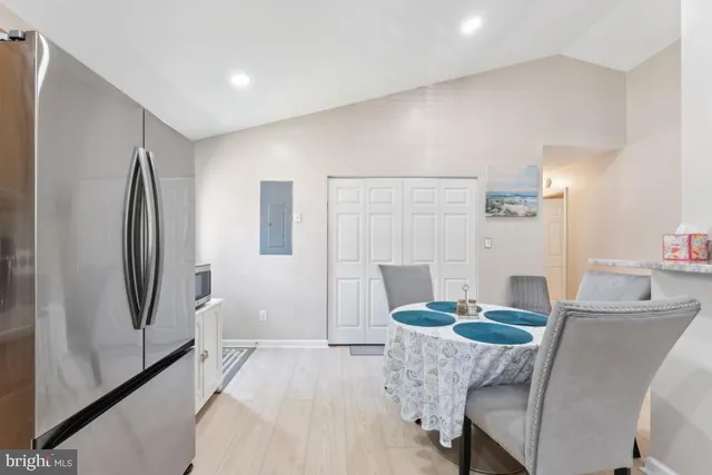 a living room with furniture and a refrigerator