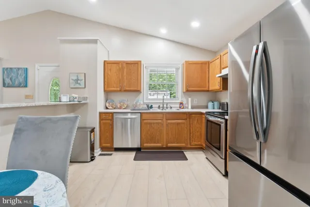 a kitchen with a sink appliances cabinets and a window