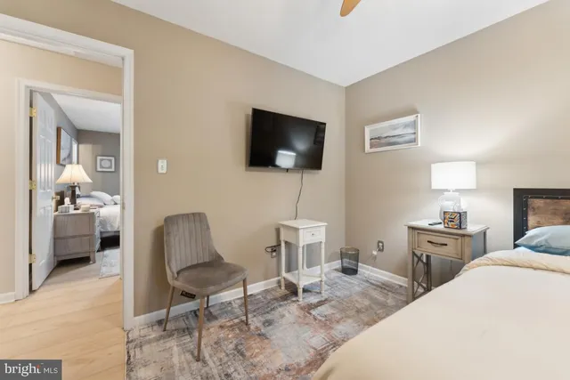 a bedroom with a bed a rug and a flat screen tv