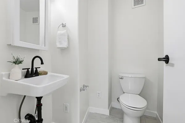 a bathroom with a toilet a sink and a mirror