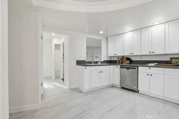 a kitchen with granite countertop white cabinets and white appliances