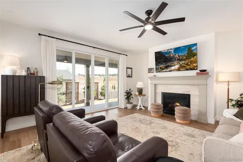 a living room with furniture a fireplace and a large window