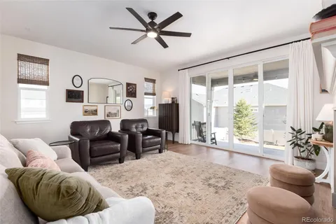 a living room with furniture ceiling fan and a window