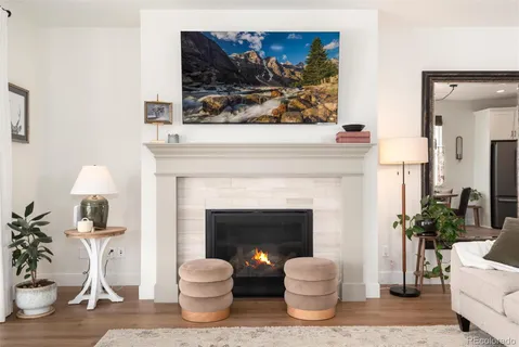 a living room with furniture a fireplace and potted plants