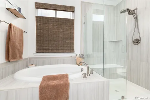 a bathroom with a tub sink and mirror