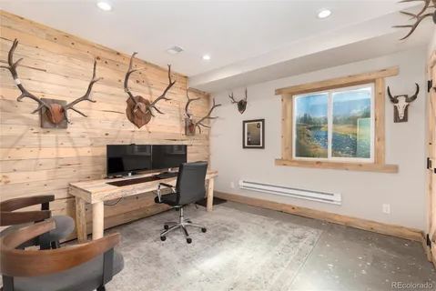 a view of a workspace with furniture and a window