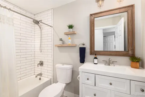 a bathroom with a sink a toilet and shower curtain