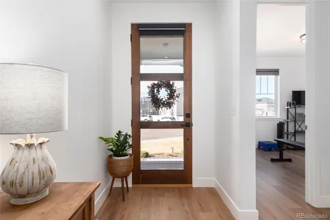 a view of a hallway with wooden floor and a potted plant