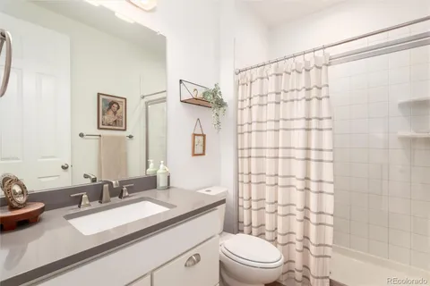 a bathroom with a sink a toilet and shower curtain