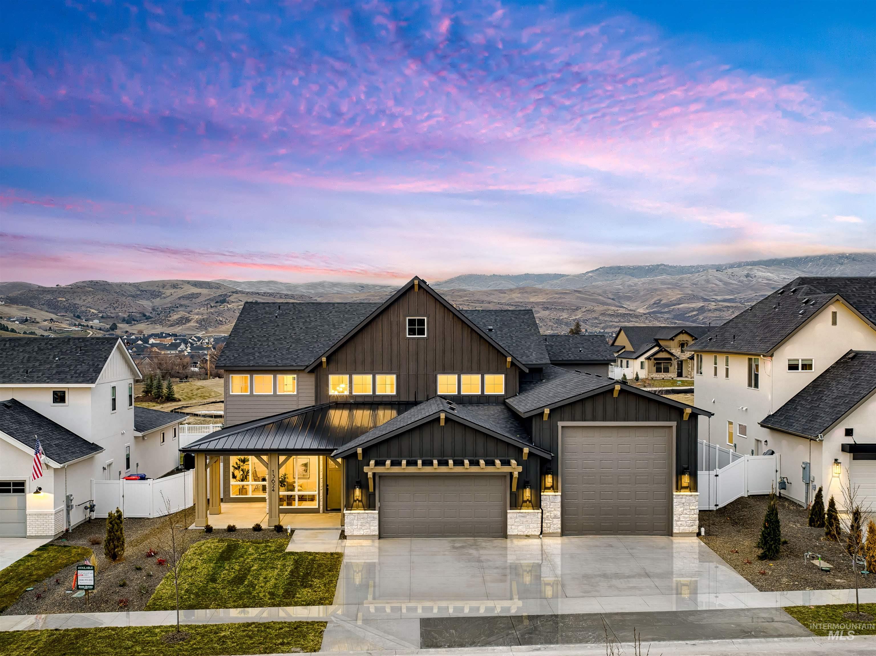 Modern farmhouse featuring board and batten siding, a gate, an attached garage, driveway, and covered porch