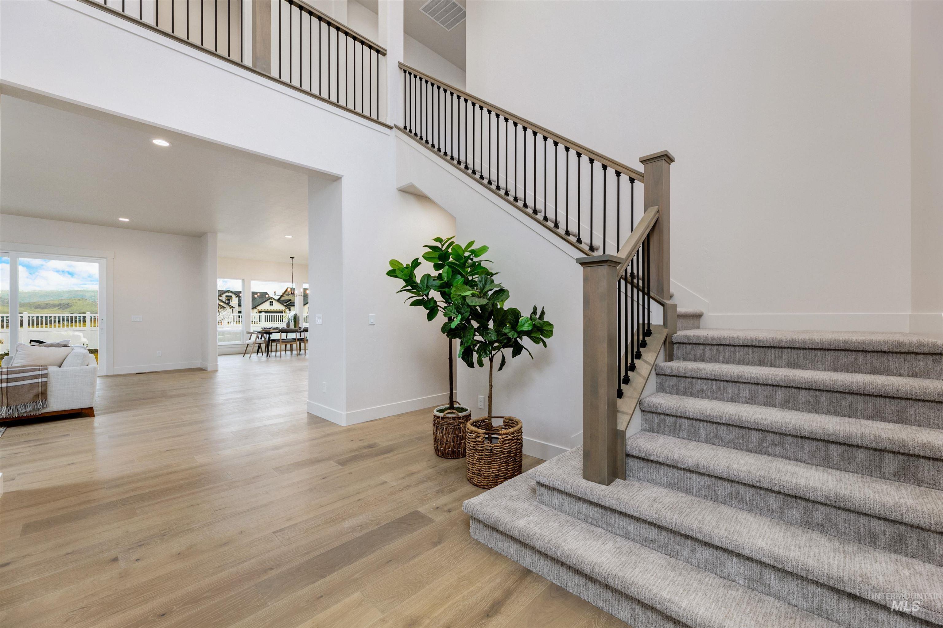 13331 North Spring Creek Way Boise, ID 83714 - Photo 20 of 43 Stairway featuring wood finished floors, recessed lighting, and a high ceiling
