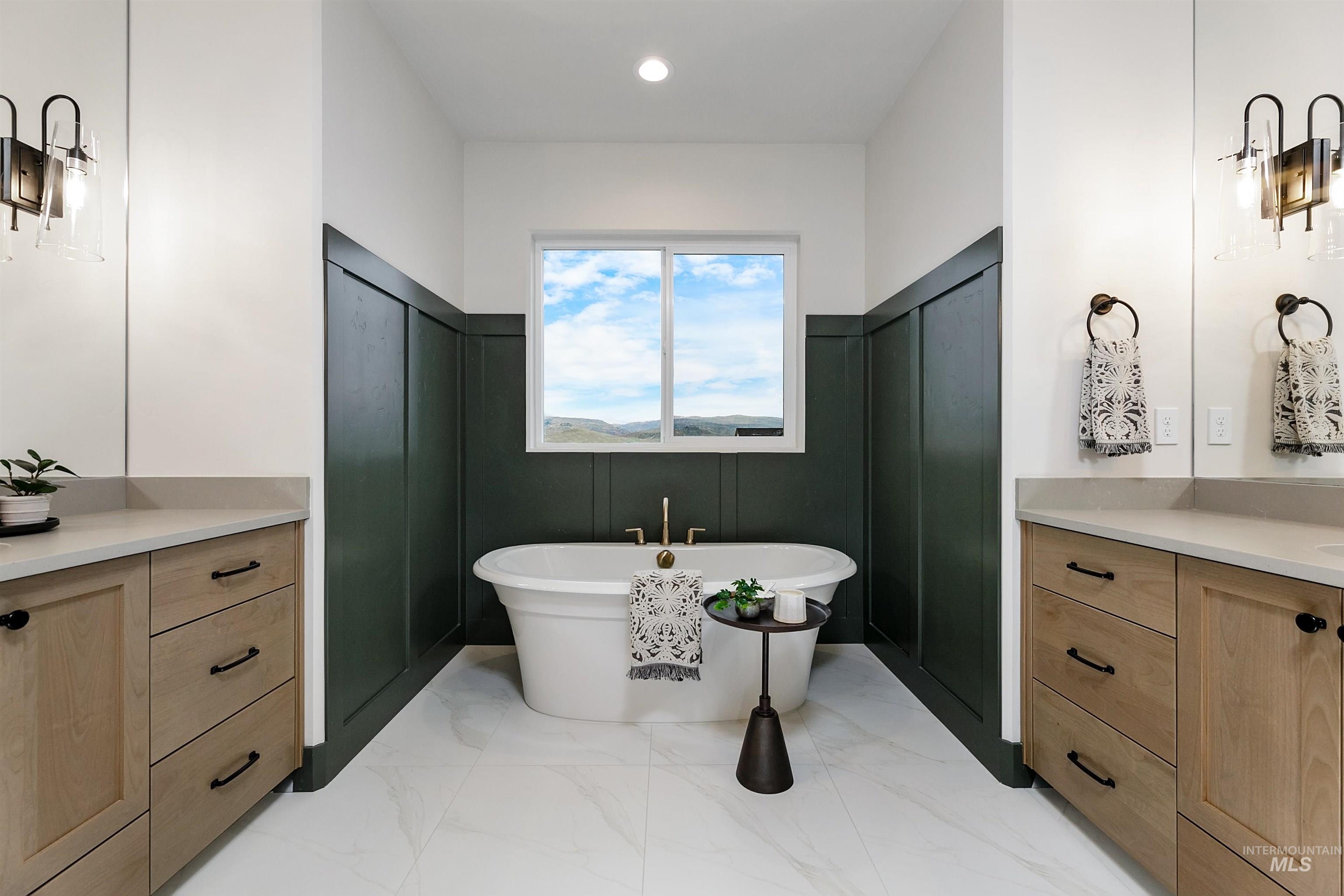 13331 North Spring Creek Way Boise, ID 83714 - Photo 24 of 43 Bathroom featuring vanity, a freestanding tub, light marble finish floors, and a wainscoted wall