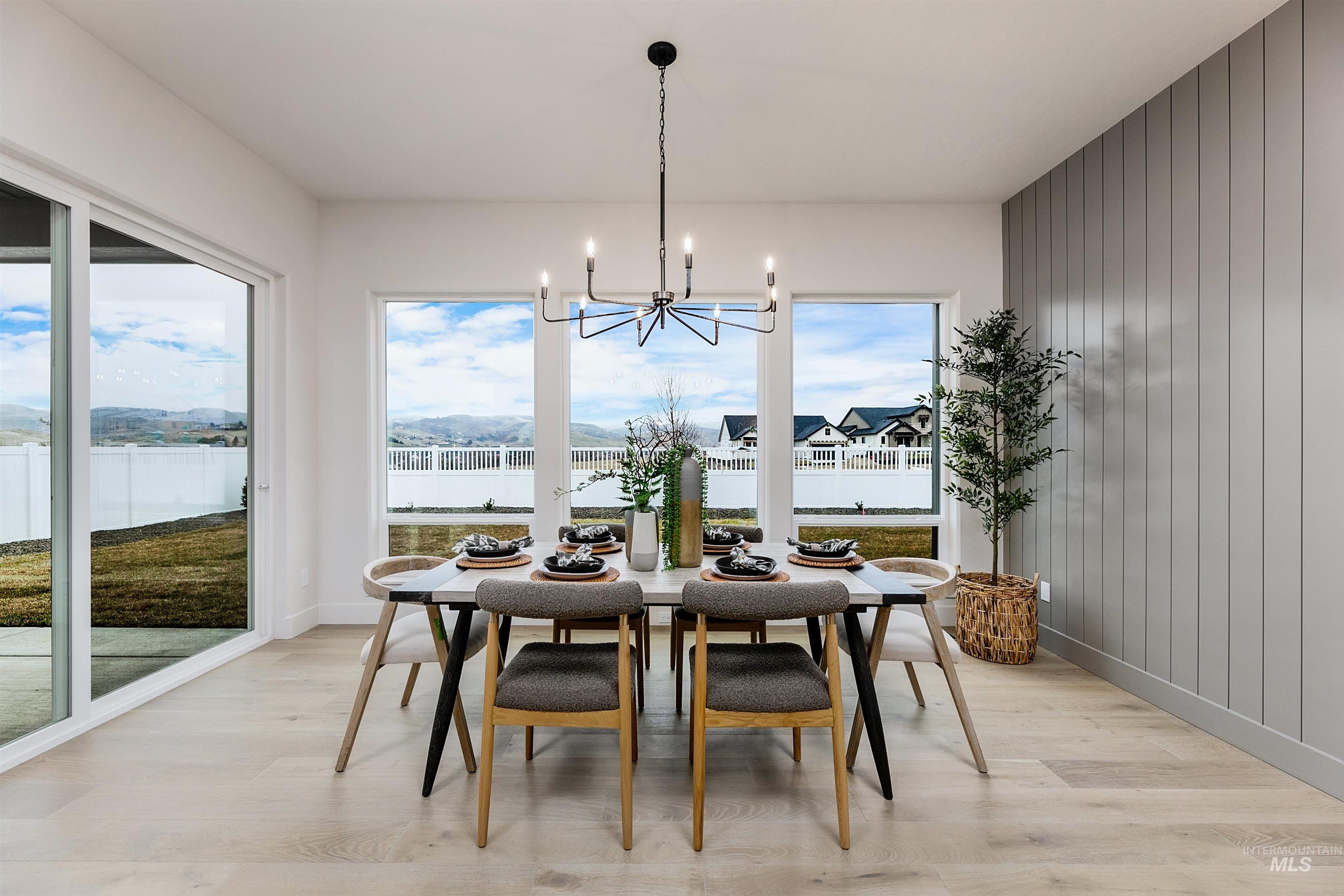 13331 North Spring Creek Way Boise, ID 83714 - Photo 7 of 43 Dining space with light wood-style flooring, wooden walls, suspended lighting, and a mountain view