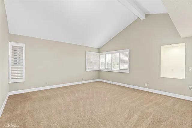 a view of an empty room with window and closet area