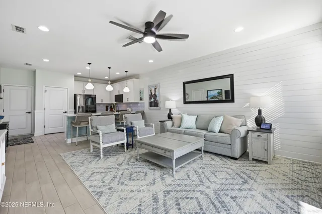 a living room with furniture and a view of kitchen