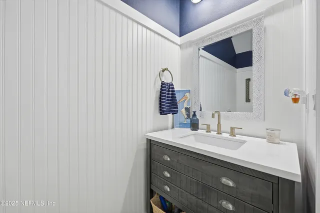 a bathroom with a sink vanity and mirror
