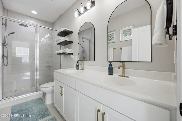 a bathroom with a double vanity sink mirror double and toilet