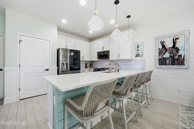 a kitchen with a dining table chairs refrigerator and microwave