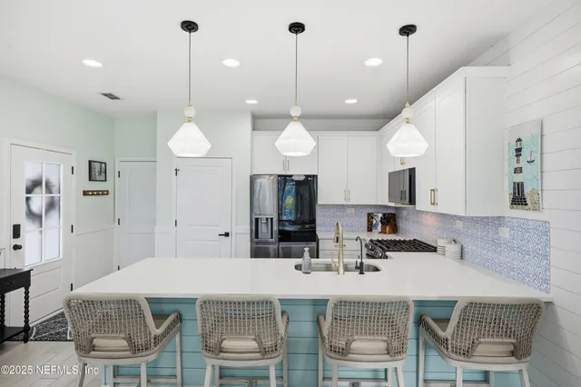 a kitchen with a dining table chairs and white cabinets