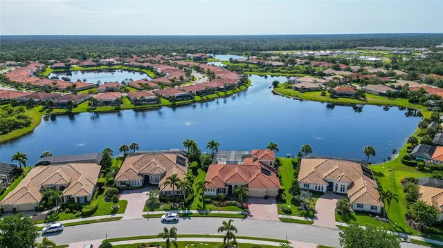 an aerial view of a house with a garden and lake view