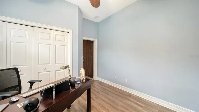 a view of an empty room with a window and wooden floor