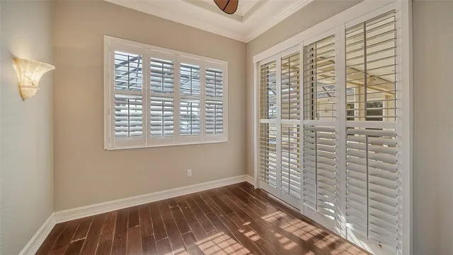 a view of a patio with table and chairs and floor to ceiling window with wooden floor