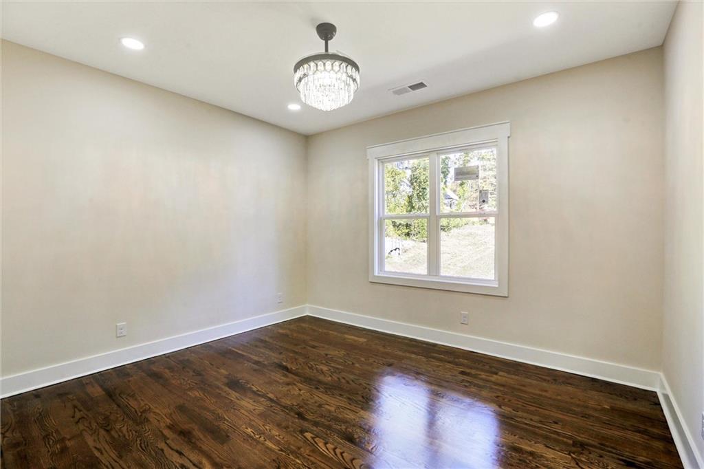 3629 Centerville Rosebud Road Snellville, GA 30039 - Photo 39 of 54 an empty room with wooden floor and windows
