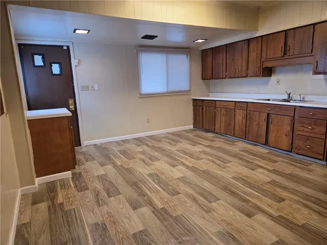 a kitchen with granite countertop a sink and wooden cabinets