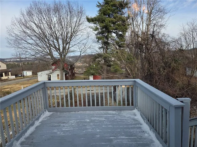 a view of a balcony with wooden fence and floor