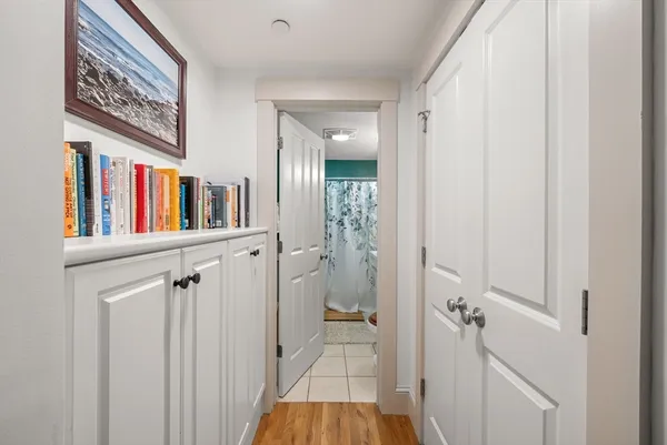 a view of a hallway with wooden floor and closet