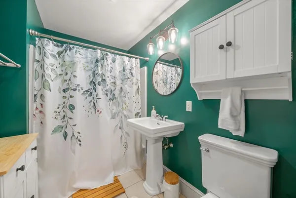 a bathroom with a sink toilet and a mirror