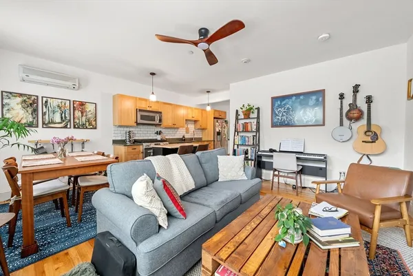 a living room with furniture kitchen view and a window