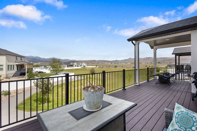 7889 Bristlecone Road Eagle Mountain, UT 84005 - Photo 35 of 42 Expansive covered deck featuring composite decking, black metal railings, and a direct sightline to distant mountains