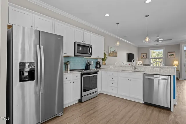 a kitchen with white cabinets and stainless steel appliances