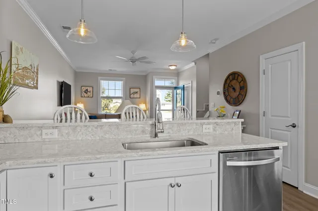 a kitchen with a sink dishwasher a clock and cabinets