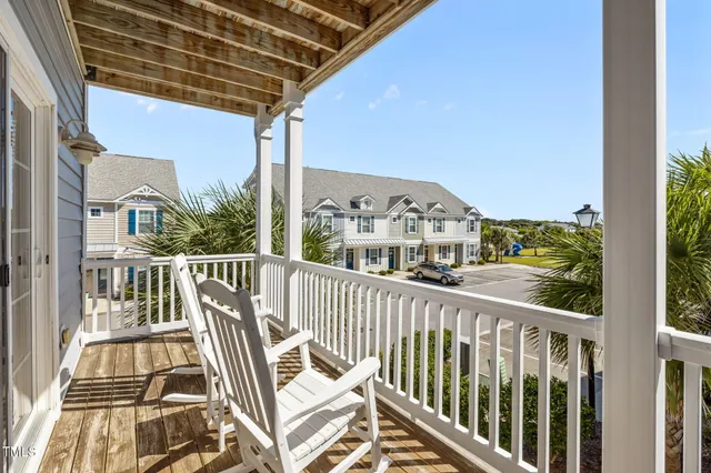 a view of a balcony with wooden floor and fence