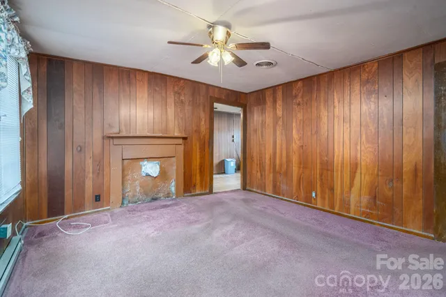 a view of an empty room with a ceiling fan and window