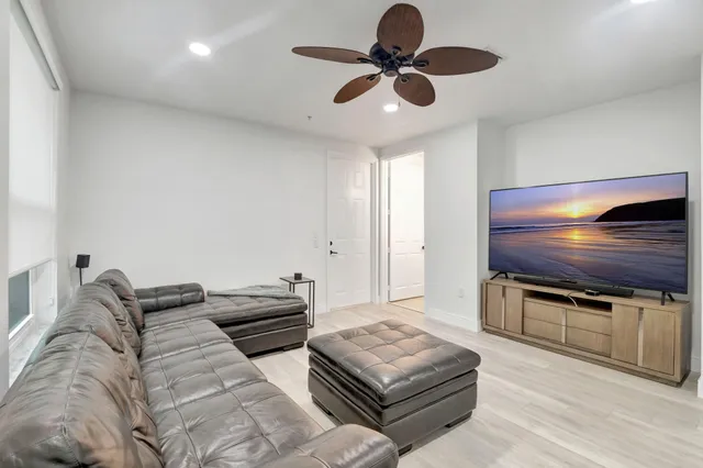 a kitchen with stainless steel appliances kitchen island granite countertop a refrigerator a sink a stove and a oven with wooden floor