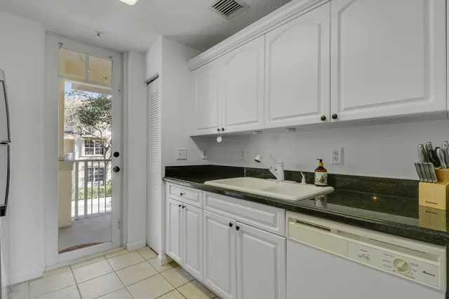 a kitchen with granite countertop white cabinets and sink
