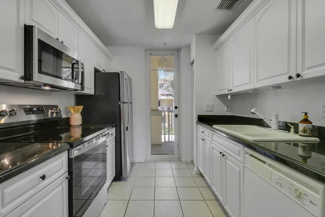 a kitchen with stainless steel appliances granite countertop a refrigerator and a stove top oven