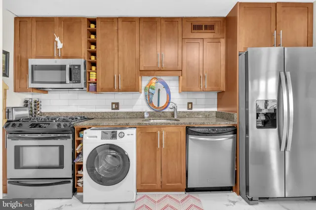 a kitchen with stainless steel appliances granite countertop a refrigerator and a stove top oven