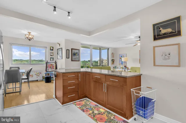 a kitchen with stainless steel appliances granite countertop a stove a sink dishwasher a dining table and chairs with wooden floor