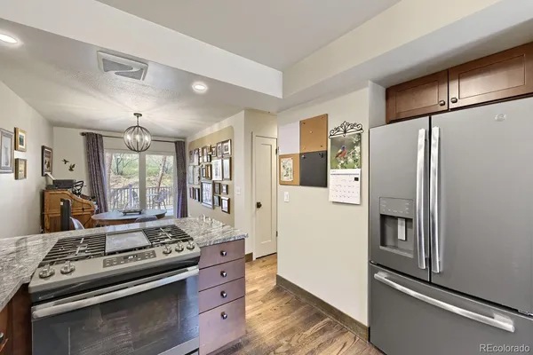 a kitchen with stainless steel appliances granite countertop a refrigerator a stove and a sink with large window