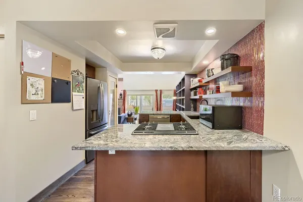 a kitchen with stainless steel appliances granite countertop a sink a stove and a refrigerator